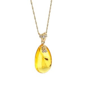 Unique gold amber pendant in the shape of an icicle with an inclusion, decorated with zircons