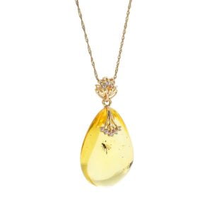 Gold unique amber pendant in the shape of an icicle, with an inclusion, decorated with zircons