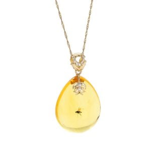 Unique gold amber pendant in the shape of an icicle with an inclusion, decorated with zircons
