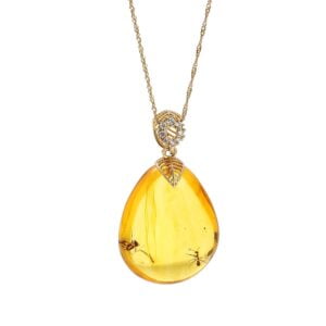 Unique gold amber pendant in the shape of an icicle with an inclusion, decorated with zircons